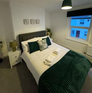 1 dormitorio con 1 cama grande y toallas. en 2-bedroom house in Cheltenham town centre, en Cheltenham