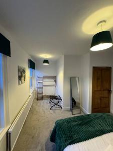 1 dormitorio con 1 cama y 1 habitación con escalera en 2-bedroom house in Cheltenham town centre, en Cheltenham