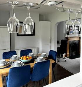 a dining room with a table and blue chairs at 2-bedroom house in Cheltenham town centre in Cheltenham