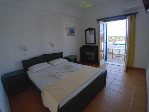 a bedroom with a bed and a door to a patio at Agnantema in Irakleia