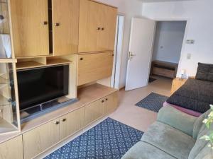 a living room with a entertainment center with a flat screen tv at Helle Ferienwohnung Nähe Köthener Altstadt in Köthen