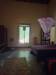 um quarto com uma cama e uma janela em Ficus Peace Villa by Mamisa Café em Habarana