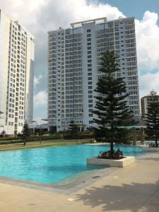a tree in the middle of a pool with buildings at WIND RESIDENCES Tagaytay Condo STAYCATION in Silang