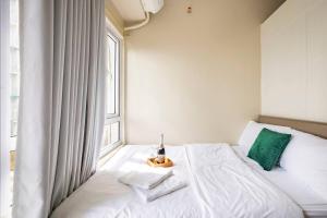 a white bed in a room with a window at WIND RESIDENCES Tagaytay Condo STAYCATION in Silang