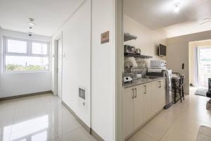 a kitchen with white cabinets and a large window at WIND RESIDENCES Tagaytay Condo STAYCATION in Silang
