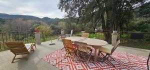 - une table et des chaises sur une terrasse avec vue dans l'établissement Les Jardins de Falguière, à Saint-Jean-du-Gard