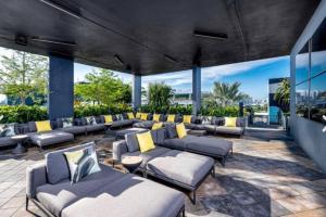 eine große Terrasse mit Sofas und gelben Kissen in der Unterkunft Modern, chic & cozy 2br 2ba apartment in Wynwood in Miami