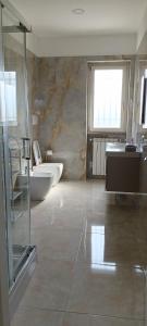 een badkamer met 2 wastafels, een toilet en een raam bij Mimì Luxury Apartment in Pompei