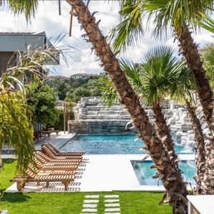 a swimming pool with lounge chairs and palm trees at SEREN OTEL ÇEŞME in Cesme