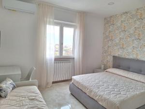 een slaapkamer met een bed en een raam bij Mimì Luxury Apartment in Pompei