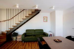 - un salon avec un canapé vert et des escaliers dans l'établissement Green House Bled, à Bled