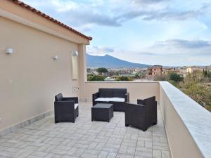 een patio met 2 stoelen en een tafel op een balkon bij Mimì Luxury Apartment in Pompei