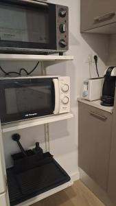 a microwave oven sitting on a shelf in a kitchen at Acogedor apartamento en el centro in Almería