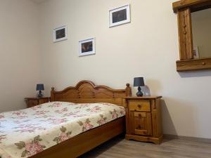 um quarto com uma cama, uma cómoda e um espelho em Tündér Pension em Mogyoród