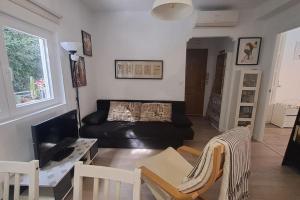 uma sala de estar com um sofá preto e uma mesa em Acogedor apartamento en el centro em Almeria