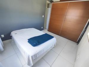a bedroom with a bed with a blue blanket on it at 1 Quarto e Sala amplo 47 m2 Vista Mar in Salvador