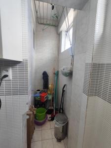 a small bathroom with a trash can and a window at 1 Quarto e Sala amplo 47 m2 Vista Mar in Salvador