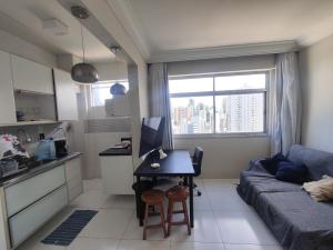a kitchen and a living room with a couch and a table at 1 Quarto e Sala amplo 47 m2 Vista Mar in Salvador
