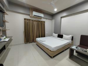 a bedroom with a bed and a television in it at HOTEL INDRAPRASTHA in Māldah