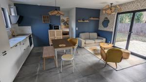 a kitchen and living room with a table and chairs at Les Gîtes du Grain Clos in Conteville