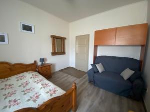 モジョロードにあるTündér Pensionのベッドルーム(ベッド1台、青いソファ付)