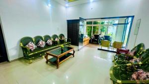 salon z zielonymi kanapami i stołem w obiekcie The RaaRees Resort - A Hidden Resort in Munnar w mieście Munnar