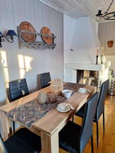 a dining room table with chairs around it with a fireplace at Øen cabin in Geilo by Norgesbooking in Geilo