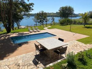 a patio with a table and chairs next to a swimming pool at Rancho Cancun - Alto Padrão - Represa de Miranda in Uberlândia