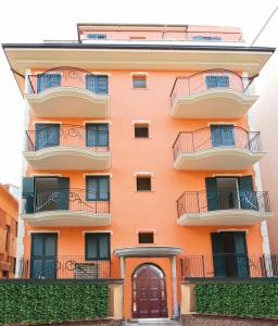 an orange building with balconies and a door at Residence Zodiaco in San Benedetto del Tronto