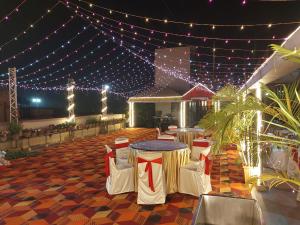 a patio with a table and chairs and lights at HOTEL INDRAPRASTHA in Māldah