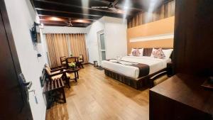 ein Hotelzimmer mit einem Bett und einem Tisch in der Unterkunft Nature Valley Resort, Lap of Nature Munnar in Munnar