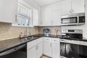 a white kitchen with a sink and a microwave at Fun Get Togethers at the Beach! in St Pete Beach