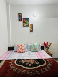 a bedroom with a large bed with pictures on the wall at Chanchal Niwas in Kharar