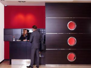 a man standing in front of a counter with a woman at Hotel Knezevina in Vranic