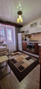 cocina con nevera blanca y fogones en Апартаменты на СОВЕТСКОЙ 39, en Petropavlovsk