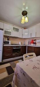 a kitchen with white cabinets and a table and a table and a table sidx sidx at Апартаменты на СОВЕТСКОЙ 39 in Petropavlovsk