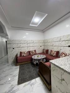 a living room with a couch and a table at شقة تتوفر على جميع شروط الراحة و الامان in Benguerir