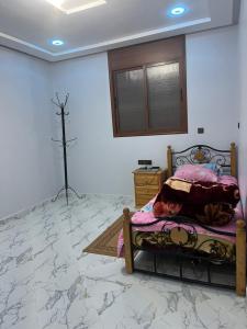 a bedroom with a bed with a cross on the wall at شقة تتوفر على جميع شروط الراحة و الامان in Benguerir