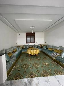 a living room with a couch and a table at شقة تتوفر على جميع شروط الراحة و الامان in Benguerir