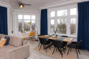 uma sala de estar com um sofá e uma mesa com cadeiras em soulscape Apartments Zwickau EDLER sanierter Altbau-Wohnraum zentrumsnah gratis WIFI em Zwickau