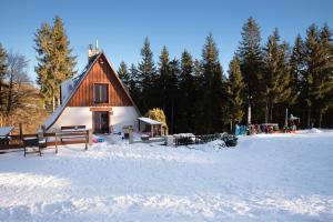 een klein huis in de sneeuw met bomen bij U Cejhonů in Měděnec