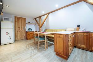 a kitchen with wooden cabinets and a table and a refrigerator at U Cejhonů in Měděnec