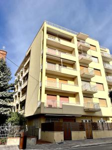 a tall yellow building with balconies on the side of it at La Casa Del Molo in Finale Ligure