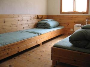 - un lit en bois dans une chambre avec fenêtre dans l'établissement Toipirka Kitaobihiro Youth Hostel, à Otofuke