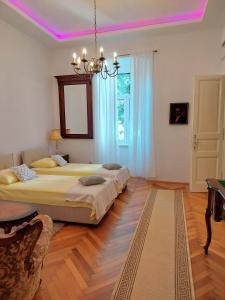a bedroom with two beds and a pink ceiling at Apartments Batala in Dubrovnik