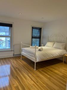 a bedroom with a white bed and a wooden floor at 93 West Road in Stratford