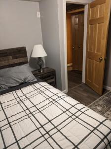 a bedroom with a bed and a lamp and a door at ECLIPSE Vermont in Colchester
