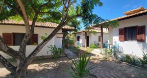 a house with a tree in front of it at Pousada Aquarela De Imbassaí in Imbassai