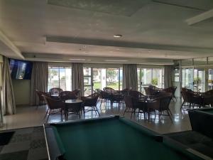 a pool table in a room with tables and chairs at Simplicity with an ocean view 200 in Hermanus