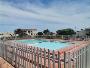 a large swimming pool with a fence around it at Simplicity with an ocean view 200 in Hermanus